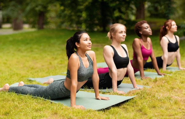 Beautiful young girls maintaining healthy lifestyle, practicing yoga outside — Stock Photo, Image