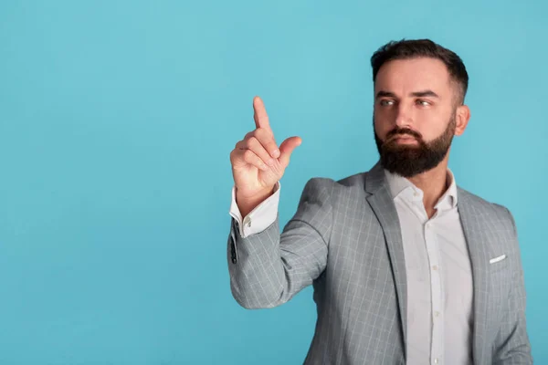 Hombre de negocios confiado tocando la pantalla virtual o presionando el botón imaginario sobre fondo azul, espacio vacío — Foto de Stock