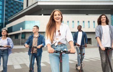 Dışarıda e-scooter süren beş genç arkadaş.