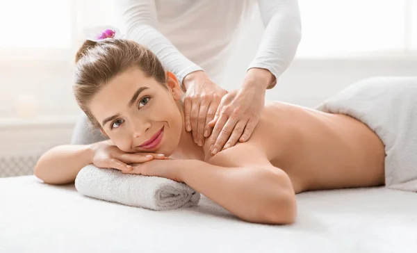 Fröhliche Dame genießt heilende Körpermassage im neuen Wellnessbereich — Stockfoto