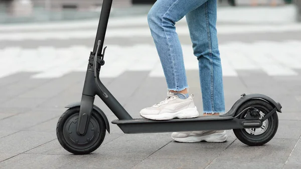 Chica de pie en scooter de patada eléctrica al aire libre — Foto de Stock