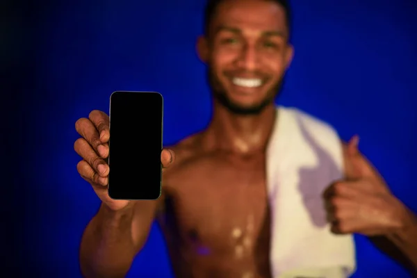 Atlet Guy Menampilkan Smartphone Layar Gesturing Thumbs-Up, Biru Latar Belakang, Mockup — Stok Foto