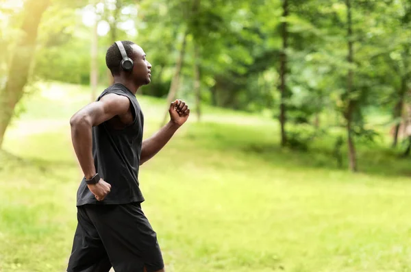 Foto de perfil de entrenamiento de jogger negro en park — Foto de Stock