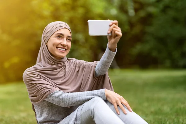 Gadis ceria dalam jilbab mengambil selfie di taman umum — Stok Foto