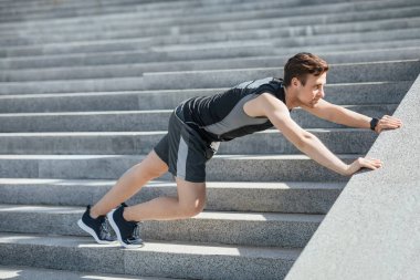 Açık hava antrenmanı. Spor aleti olan bir adam merdivenlerde egzersiz yapıyor.