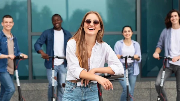 Cinco amigos tendo passeio em scooters chute motorizado ao ar livre — Fotografia de Stock