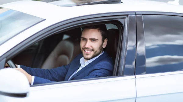 Boldog vezérigazgató ül a vezetőülésen a kocsiját, megy dolgozni a nagyvárosban — Stock Fotó