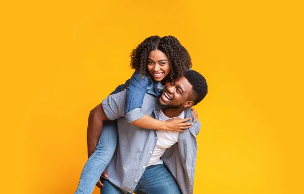 Χαρούμενο ζευγάρι Αφρικανών που διασκεδάζουν μαζί, ο Γκάι πηδάει την κοπέλα του — Φωτογραφία Αρχείου