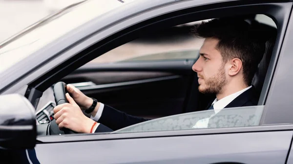 Uomo d'affari concentrato che guida da solo nella sua nuova auto — Foto Stock