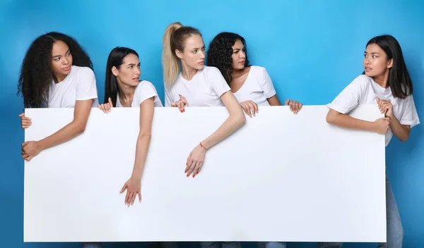 Unfriendly niñas tirando aparte blanco tablero de pie sobre azul fondo — Foto de Stock