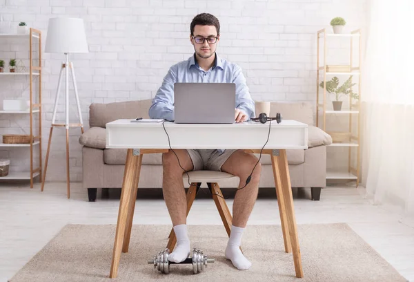 Βίντεο και δουλειά από το σπίτι. Άνδρας με γυαλιά, πουκάμισο, σορτς και κάλτσες στο χώρο εργασίας, με αλτήρα — Φωτογραφία Αρχείου