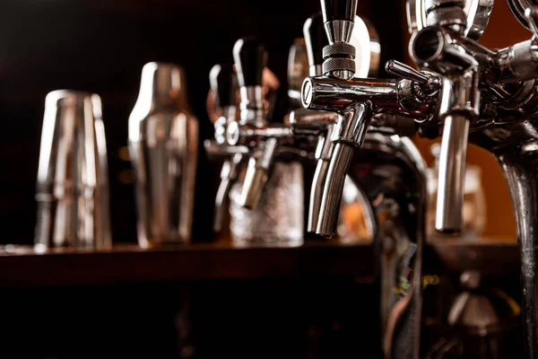 Rubinetti metallici per birra artigianale e strumenti da barista all'interno del pub — Foto Stock