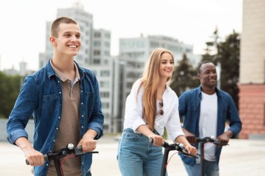 Şehirde motorlu scooter kullanan arkadaşlar.
