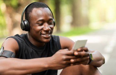 Mola sırasında akıllı telefon kullanan gülümseyen sporcuya yakın çekim