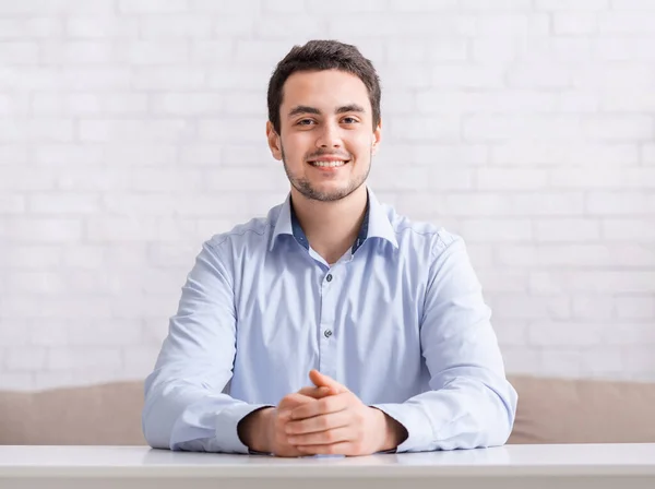 Reunião online e trabalho em casa. Sorrindo cara amigável na camisa com as mãos na mesa — Fotografia de Stock