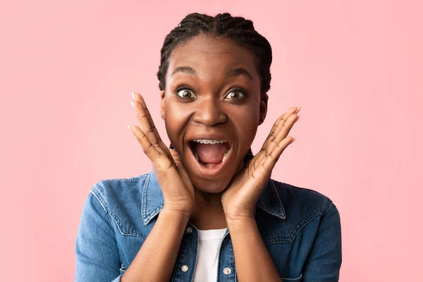 Mulher negra surpreso gritando em emoção posando sobre fundo rosa — Fotografia de Stock