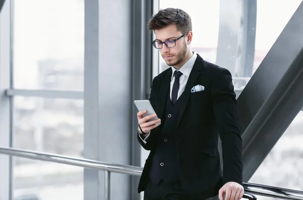 Uomo d'affari urbano sms su smart phone in aeroporto — Foto Stock