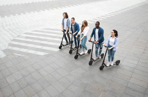 Cinco amigos teniendo agradable paseo en scooters de patada eléctrica — Foto de Stock