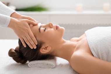 Genç kadın spa 'da kafa masajı yaptırıyor.