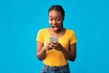 Heyecanlı Siyah Kadın Cep Telefonu Kullanıyor Mavi Stüdyo Arkaplanda Duruyor
