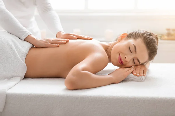 Female therapist making massage to young woman