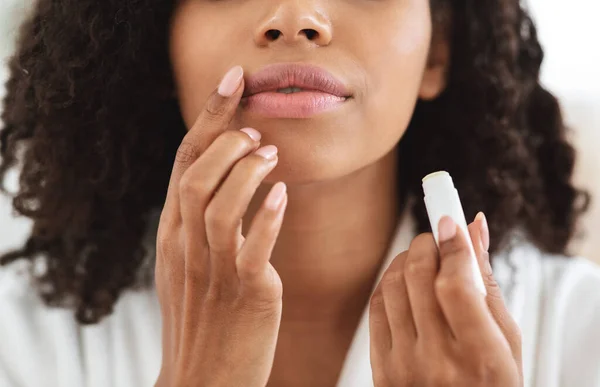 Perawatan bibir. Wanita kulit hitam tak dikenal yang mengoleskan pelembab pada bibir, menutup — Stok Foto