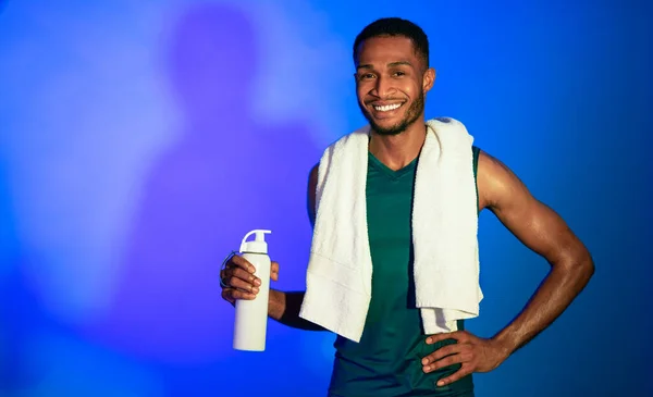 Africano aptitud chico celebración botella de agua de pie en estudio — Foto de Stock