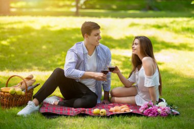 Millennial evli çift yaz pikniğinde şarap içiyor.