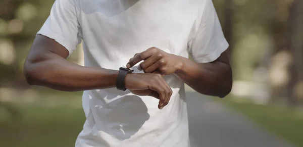 Zwarte man het controleren van zijn activiteit status op smartwatch — Stockfoto