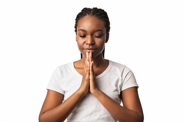 Mulher negra orando de mãos dadas em gestos de oração, fundo branco — Fotografia de Stock