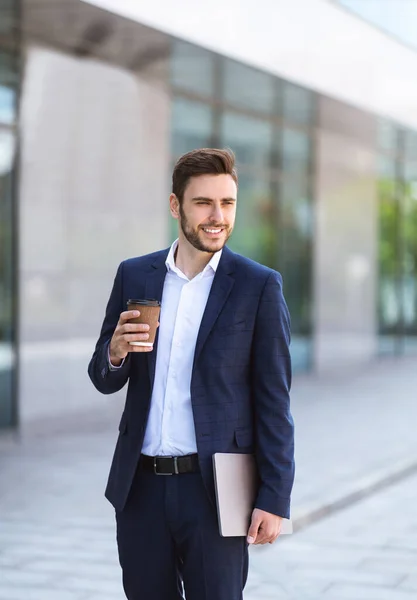 Gerente de negócios atraente com café e tablet perto de seu prédio de escritórios na cidade grande — Fotografia de Stock