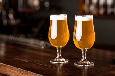 Pub 'da randevum var. Bardaklar hafif bira ve köpükle barın içindeki ahşap tezgahta.