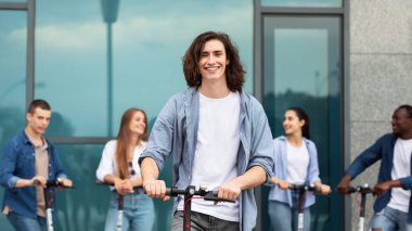 Dışarıda e-scooter kullanan beş arkadaş.