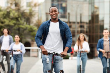 Beş heyecanlı arkadaş elektrikli scooterlara biniyor.