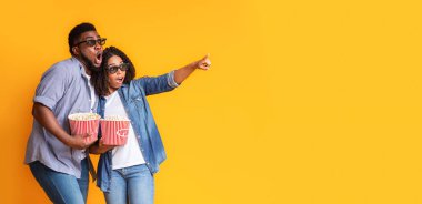 Şok edici bir teklif. Fotokopi uzayını işaret eden patlamış mısır kovalı hayret verici siyah çift