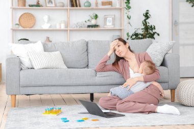 Emzirme hüsranları. Rahatsız Genç Kadın Emziren Bebek, Evde Yerde Oturan
