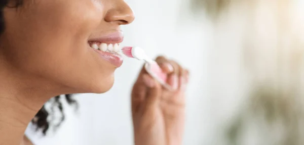 मौखिक स्वच्छता। ब्लैक वुमन ब्रशिंग उसकी सही सफेद दांतों का क्लोजअप — स्टॉक फ़ोटो, इमेज