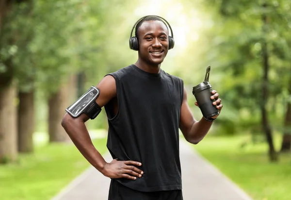 Joven negro bebiendo agua mientras entrena en el parque —  Fotos de Stock