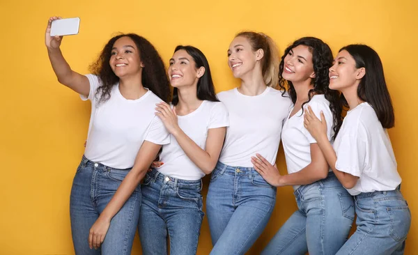 Glad mångfald kvinnor att göra selfie Posing på gul studio bakgrund — Stockfoto