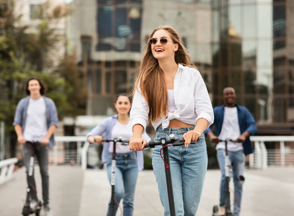 Adolescentes que têm passeio em scooters pontapé elétrico — Fotografia de Stock