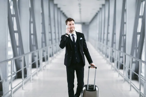 Homem de negócios feliz falando no smartphone no aeroporto — Fotografia de Stock