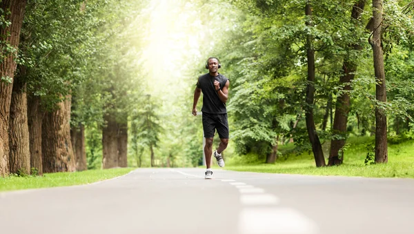 Motivated african sportsman jogging at city park — Stock Photo, Image