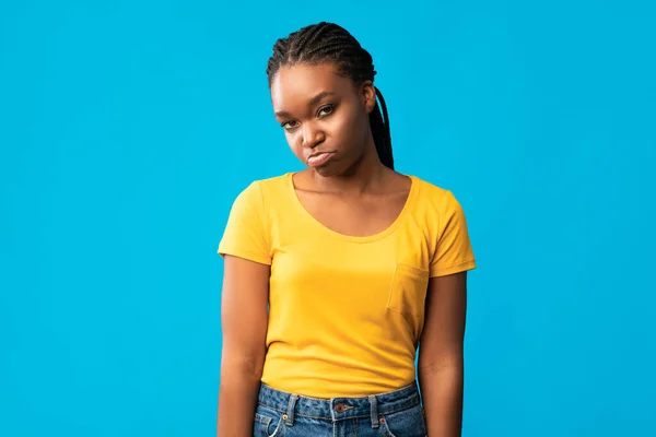 Sértett afro-amerikai lány duzzogó néz kamera, kék háttér — Stock Fotó