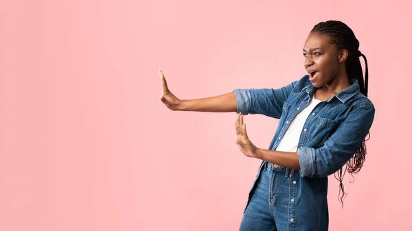 Afro-americana chica gestos dejar de mirar a un lado en rosa fondo — Foto de Stock