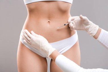 Sıska kadın güzellik salonunda lipolizis tedavisi görüyor.