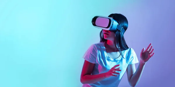 Alta tecnologia para jogos. Menina em óculos virtuais à luz do néon — Fotografia de Stock