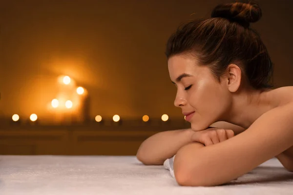 Schlafende Dame liegt auf Massagetisch im Wellnessbereich — Stockfoto