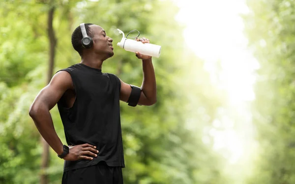 African sportsman drinking water, having break during exercising — Stock Photo, Image