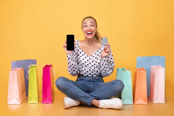 Donna felicissima con borse della spesa, telefono e carta di plastica — Foto Stock
