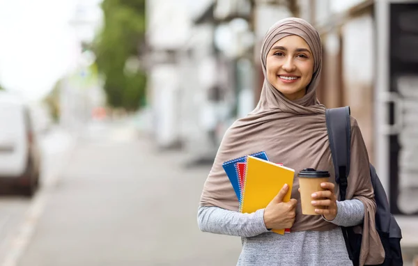 Glada flicka i hijab med morgonkaffe på gatan — Stockfoto